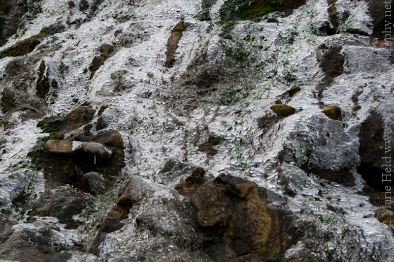 Icy sheet on top of the cliff edge created by trickling water in frosty weather.